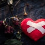 First Aid Band Cushioned Plaster Strip Medical Patch glued on red heart.